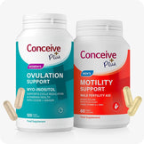 Conceive Plus Motility and Ovulation Support Bundle with two white supplement bottles—one teal-labeled for women's ovulation support and other red-labeled for men's motility support—displayed upright with scattered two beige and two yellow capsules in front, set against white background.