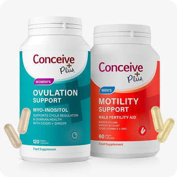 Conceive Plus Motility and Ovulation Support Bundle with two white supplement bottles—one teal-labeled for women's ovulation support and other red-labeled for men's motility support—displayed upright with scattered two beige and two yellow capsules in front, set against white background.