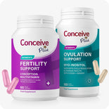 Conceive Plus Women's Fertility Support and Ovulation Support Bundle with two bottles side by side—one in purple labeled “Women's Fertility Support” with 60 vegan capsules, and one in teal labeled “Women's Ovulation Support” with 120 vegan capsules. Pink and beige capsules float near each bottle, emphasizing dual supplement design against white background.