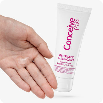 Conceive Plus Fertility Lubricant 75ml tube held beside an open palm with a visible dab of clear lube from 75ml fertility lubricant tube, smooth lubricant gel, highlighting product’s non-sticky texture and sperm-friendly formulation for couples trying to conceive.