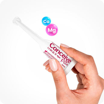 For Conceive Plus Max Fertility Bundle (75ml Tube and 16 Applicators), a hand gently holding a single 4g pre-filled fertility lubricant applicator with visible product labeling, accompanied by floating calcium (Ca) and magnesium (Mg) ion icons to emphasize fertility-supportive ingredients, all set against white background.