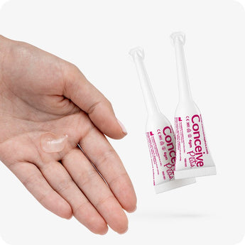 For Conceive Plus Max Fertility Bundle (75ml Tube and 16 Applicators), two 4g pre-filled fertility lubricant applicators next to an open hand displaying a small amount of clear fertility lubricant gel, offering a detailed view of product texture and delivery format against white background.